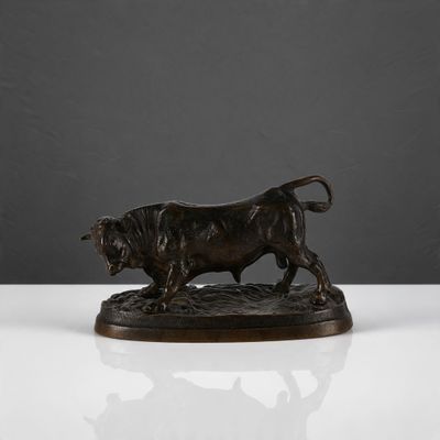 une figurine en bronze représentant un taureau sur un fond blanc