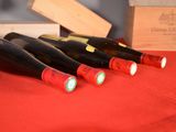 several bottles of wine are lined up on a red table