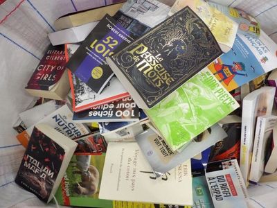 une pile de livres dans un sac posé sur un lit