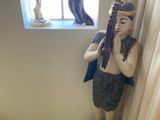 une statue représentant un homme tenant un pistolet devant une fenêtre