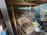 a pile of wood and a broom in the corner of a room