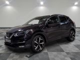 un SUV Nissan de couleur foncée garé sur un sol à damier