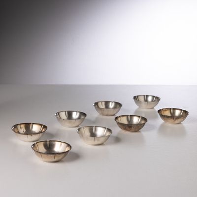 six silver bowls are arranged in a row on a white surface