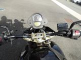a close up of a motorcycle ' s handlebars on a city street