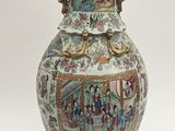 a vase with a painting on it sitting on a table