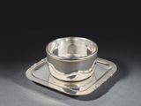 une tasse et une soucoupe en argent posées sur un plateau
