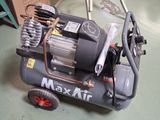 un petit compresseur d'air posé par terre à côté d'un chariot