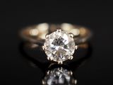 a close up of a diamond ring on a black surface