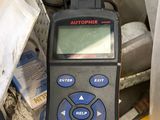 une télécommande posée au sommet d'une pile d'objets divers