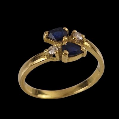 Gros plan sur une bague en or ornée d'un saphir bleu et de diamants