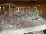 de nombreux verres à vin posés sur une étagère dans la cuisine