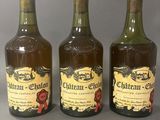 trois bouteilles de vin sont alignées sur une table