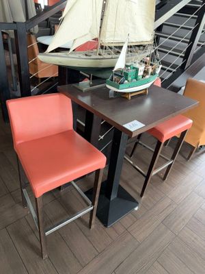 a table with two chairs and a model of a sailboat on top of it
