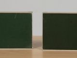 pair of green and white square tiles sitting on top of a wooden table