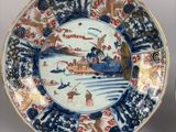 two plates with designs of boats and people on them on a table