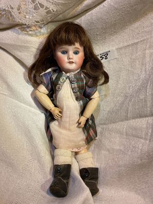 a doll that is laying down on a white sheet