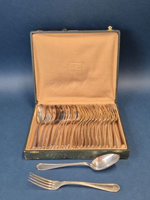 des couverts dans un coffret, avec des cuillères posées sur un fond bleu