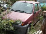 a red car that is sitting in the weeds