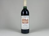 une bouteille de vin rouge posée sur une table blanche