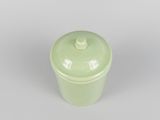 a green cup with a lid sitting on a table