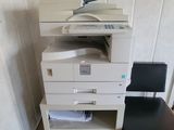 a printer and a chair in the corner of a room