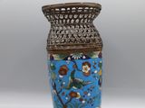 un vase bleu orné d'un oiseau, posé sur une table