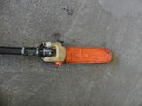 an orange and black pipe cutter laying on the ground