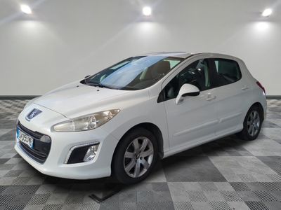 une voiture blanche est garée dans une pièce au sol à carreaux