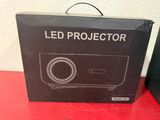 an open box of a projector sitting on top of a red table