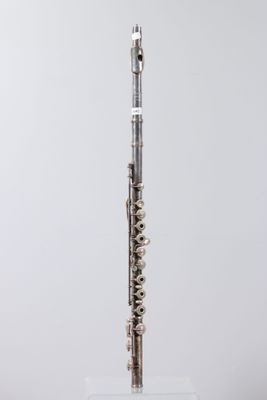 a silver flute on a clear stand against a white background