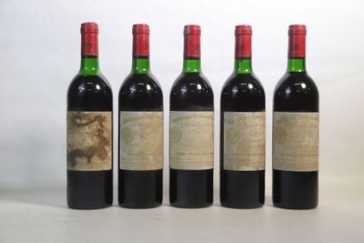 quatre bouteilles de vin sont alignées sur une surface blanche