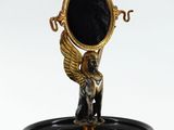 une statue représentant un ange tenant un miroir posé sur un plateau