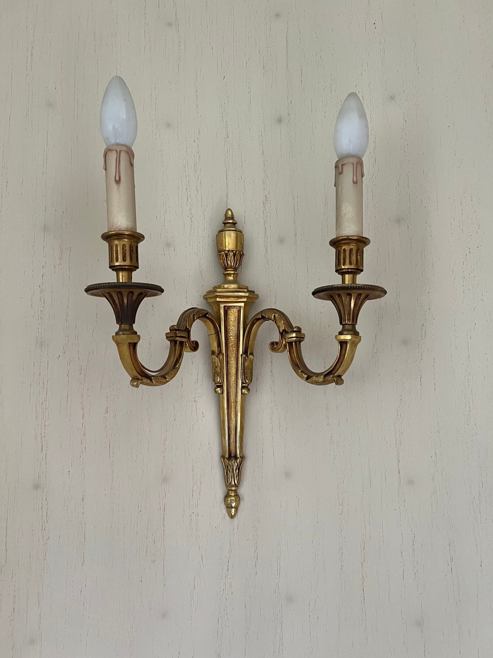 PAIRE D'APPLIQUES à deux lumières en bronze doré.