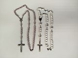 trois grains de chapelet et une croix sur un fond blanc