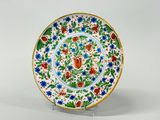 une image représentant une assiette décorative ornée de fleurs et de feuilles