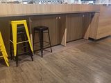 two yellow stools sitting in front of a counter