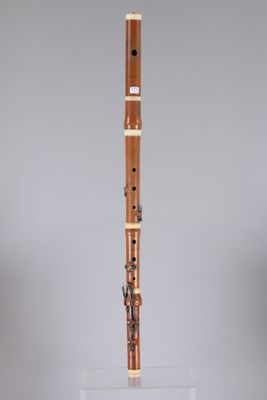 a wooden flute on a clear stand with a grey background
