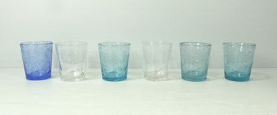 six verres de couleurs différentes alignés sur une table