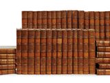 many books stacked on top of each other on a white surface