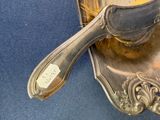 a silver spoon sitting on top of a silver plate