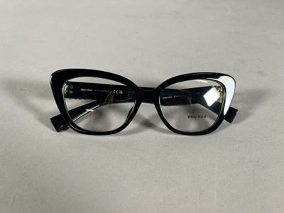 black and white cat eye glasses on a white surface