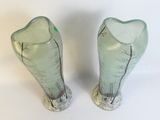 two glass vases with trees in them on a white surface