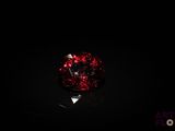 a close up of a red glass ball on a black surface