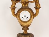 a gold clock with angels on it on a white background