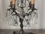 a small crystal chandelier on a table next to a lamp
