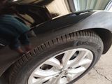 a man working on the tire of a black car