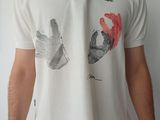 un homme portant une chemise blanche sur laquelle est représentée une main