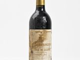 une vieille bouteille de vin posée sur une surface blanche