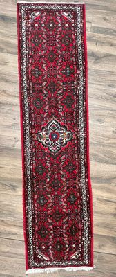un tapis rouge allongé sur un parquet, à côté d'un parquet
