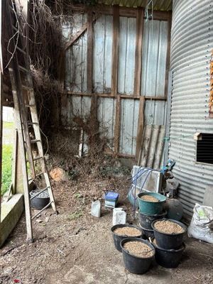 many buckets of dirt in front of a silo